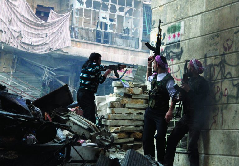In this Saturday, Dec. 29, 2012 photo, Free Syrian Army fighters fire at enemy positions during heavy clashes with government forces, in the Salaheddine district of Aleppo, Syria. Activists say Syrian rebels have captured an oil pumping station in the north central province of Raqqa about 160 km east of Aleppo after days of fighting. (AP Photo/Abdullah Al-Yasin)