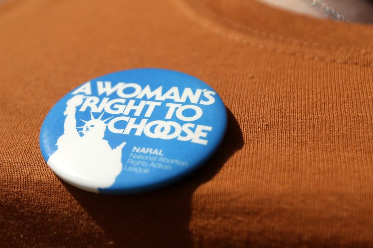 A supporter shows off a pin on her shirt as she attends a rally, Wednesday, July 10, 2013, in Dallas. (AP Photo/Tony Gutierrez)