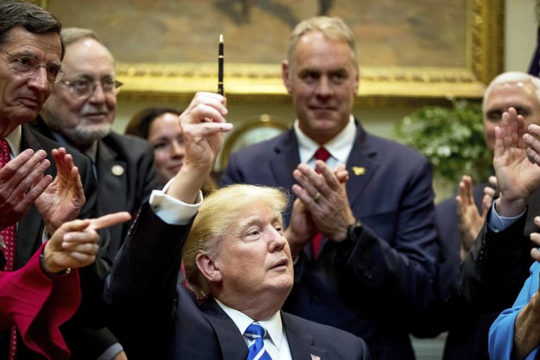 President Donald Trump holds up a pen he used to sign one of various bills in the Roosevelt Room of the White House in on March 27. From left are, Sen. Tom Barrasso, R-Wyo., Rep. Don Young, R-Alaska, Interior Secretary Ryan Zinke and Vice President Mike Pence. (AP Photo/Andrew Harnik)