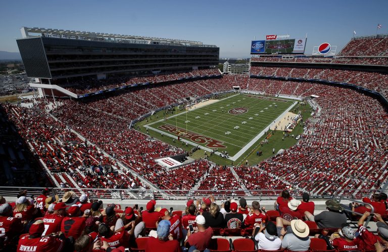 FILE - In this Aug. 17, 2014, file photo, fans watch as the San Francisco 49ers play the Denver Broncos during the first quarter of an NFL preseason football game at Levi's Stadium in Santa Clara, Calif. In the not-too-distant future, a football fan might be able to take his seat at the stadium, punch up any game he wants on the monitor set in the seatback in front of him, keep tabs on the real-time stats of his fantasy team, order up a hot dog and beer and even have a brand-new jacket brought to his seat if the wind kicks up. This is the future of the NFL _ the $9 billion league that kicked off the 2014 season this week and has plans on going bigger over the next decade. (AP Photo/Tony Avelar, File)