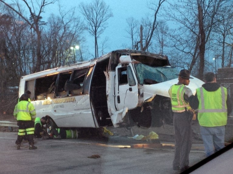 This photo provided by the Virginia State Police,  police investigate the scene of a bus accident on Interstate 95, early Sunday, March 23, 2014 in Fairfax County, Va.  The shuttle bus struck a guardrail and overturned before dawn Sunday just south of the nation's capital, leaving at least one person dead and sending 16 others to the hospital, Virginia State Police said.  The bus was headed south on the heavily traveled East Coast artery when witnesses reported a white, speeding four-door passenger vehicle swerved into the bus's travel lane. The bus then swerved to the right to avoid the sedan, ran off the road, struck the guardrail and overturned, Virginia State Police said. The crash occurred on the interstate in northern Virginia's Fairfax County and police were called at 3:28 a.m. Sunday, State Police spokeswoman Corinne Geller said. (AP Photo/Virginia State Police)