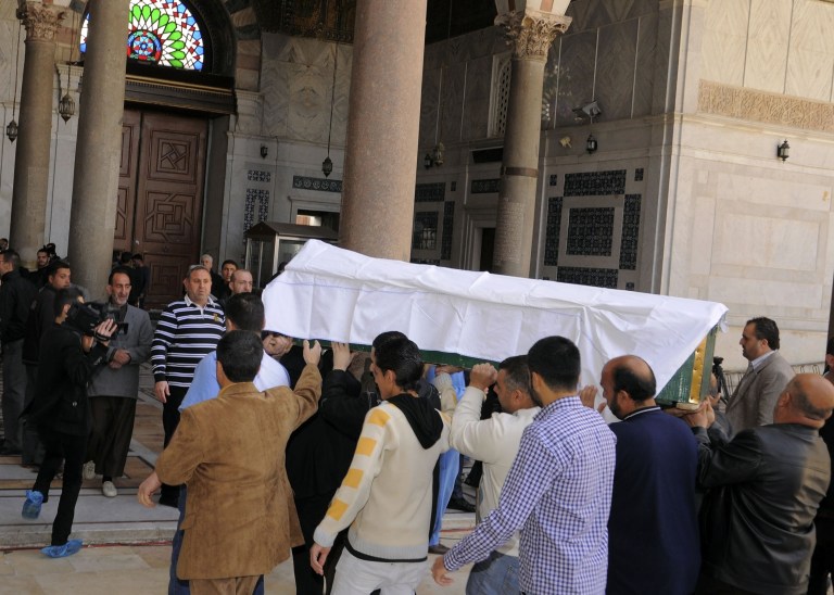 In this photo released by the Syrian official news agency SANA, mourners carry the body of Sheik Mohammad Said Ramadan al-Buti, an 84-year-old pro-government cleric, into the eighth century Omayyad Mosque, in Damascus, Syria, Saturday, March 23, 2013. Al-Buti, his grandson and scores of others were killed Thursday, March 21, 2013 when a suicide bomber detonated his explosives inside a mosque where al-Buti was giving a religious lesson. His assassination was a blow to Assad, who vowed Friday to avenge his death. (AP Photo/SANA)