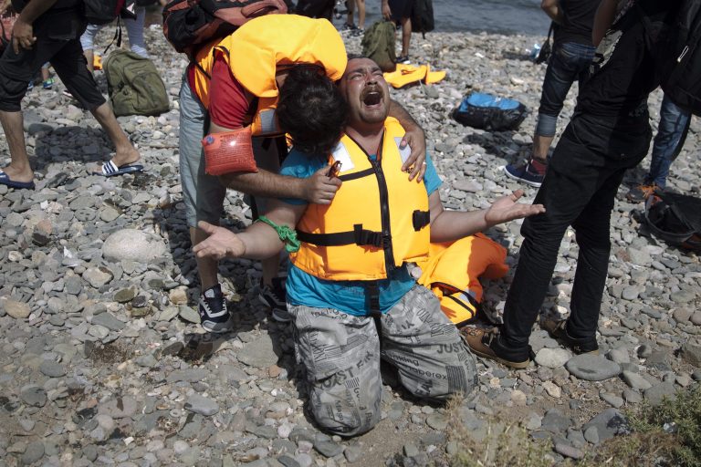 Syrian refugees react as they arrive after crossing aboard a dinghy from Turkey, on the island of Lesbos, Greece, on Sept. 7. The island has been transformed by the sudden new population of some 20,000 refugees, mostly from Syria, Iraq and Afghanistan. (AP Photo)