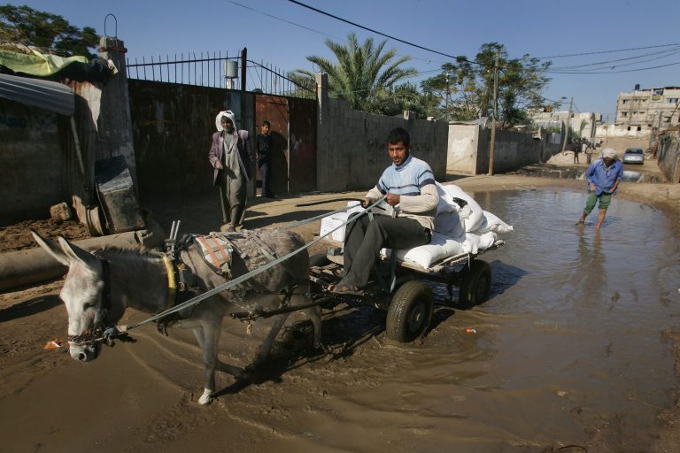 Residents of a marginal Palestinian Bedouin community outside Gaza City make their way through streets that flooded after recent rains on November 3, 2008 in Malalha in Gaza. (Photo by Abid Katib/Getty images)