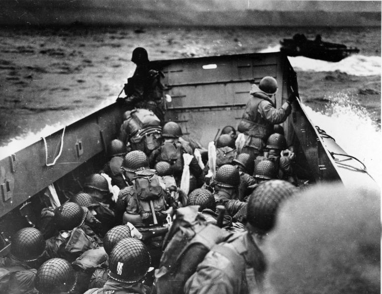Allied troops crouch behind the bulwarks of a landing craft as it nears Omaha Beach during a landing in Normandy, France. Allied troops in the D-Day invasion landed on the Normandy coast of France in tremendous strength by cloudy daylight and stormed several miles inland with tanks and infantry in the grand assault that Gen. Dwight D. Eisenhower called a crusade in which 