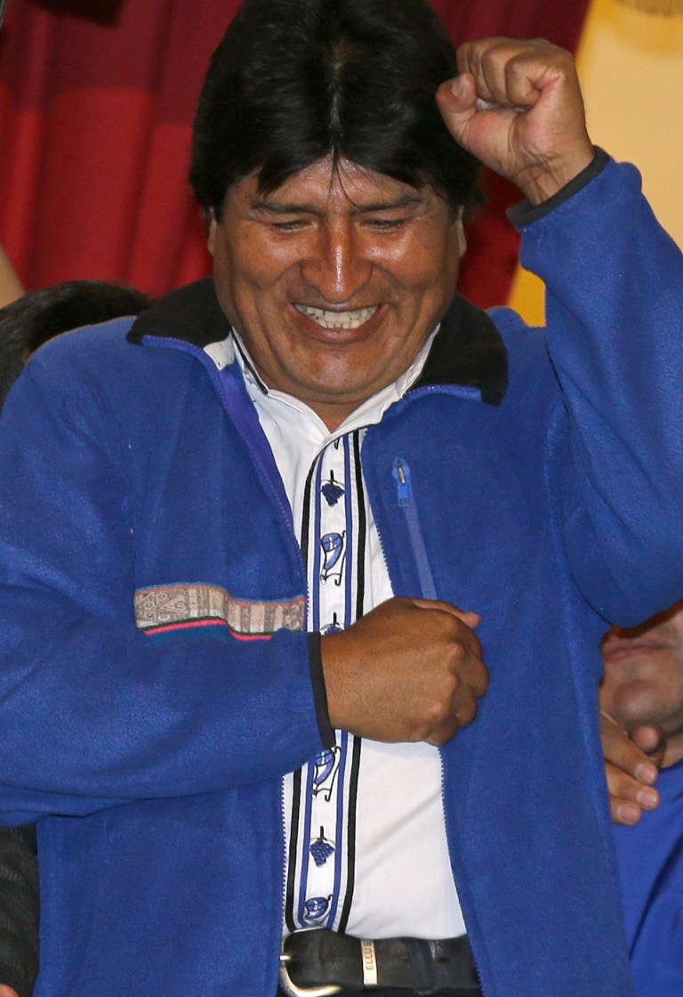 Bolivia's President Evo Morales greets supporters from the balcony of the presidential palace in La Paz, Bolivia, Sunday Oct. 12, 2014.  Evo Morales easily won an unprecedented third term as Bolivia's president Sunday according to an unofficial quick count of the vote. At left is Vice President Alvaro Garcia.(AP Photo/Martin Mejia)