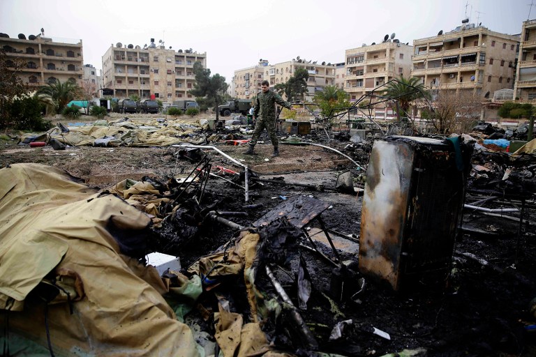 A Russian soldier checks a burned medical tent after rebels launched a mortar shell at a field hospital in west Aleppo, Syria, Monday, Dec. 5, 2016. (AP Photo/Hassan Ammar)