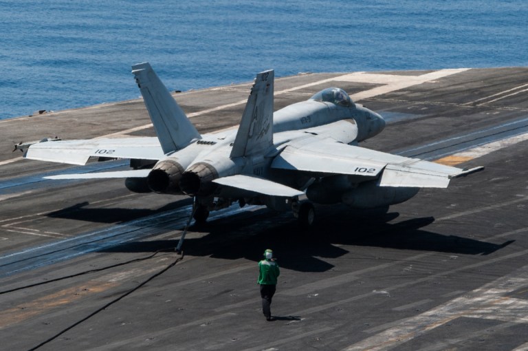 In this Friday, Oct. 24, 2014 photo released by the U.S. Navy, an aircraft lands on the flight deck of the aircraft carrier USS George H.W. Bush on the Persian Gulf. The aircraft carrier and aircrafts are deployed as part of operations targeting the Islamic State of Iraq and Syria. (AP Photo/U.S. Navy, Brian Stephens)