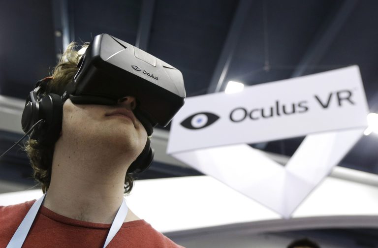 FILE - In this March 19, 2014 file photo, Peter Mason tries the Oculus virtual reality headset at the Game Developers Conference 2014 in San Francisco. Oculus, the virtual reality company acquired by Facebook earlier this year for $2 billion, is holding its first-ever developers conference and is expected to discuss the much-anticipated release of its VR headset for consumers. The two-day Oculus Connect conference begins Friday, Sept. 19, 2014.  (AP Photo/Jeff Chiu, file)
