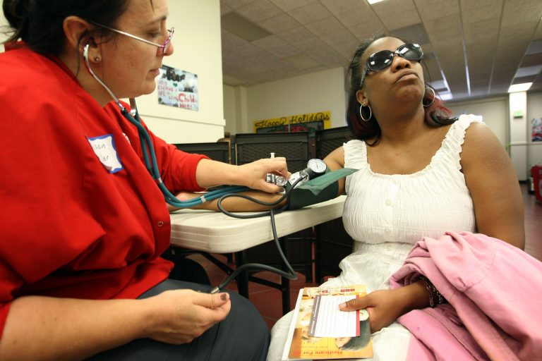 LOS ANGELES, CA - JULY 10:  Nurse Allison Miller (L) checks the blood pressure of Keri Anderson as nurses and physicians give free basic health screenings and call attention to what they say is the ongoing healthcare emergency despite the decision of the U.S. Supreme Court to uphold the Affordable Care Act, on July 10, 2012 in Los Angeles, California. Three days of free screenings in the Los Angeles area are part of the Medicare for All tour which is making up to two dozen stops across California between June 19 and July 12. The California Nurses Association says that 30 percent of Los Angeles County adults are uninsured and 18 percent cannot afford doctor visits.   (Photo by David McNew/Getty Images)