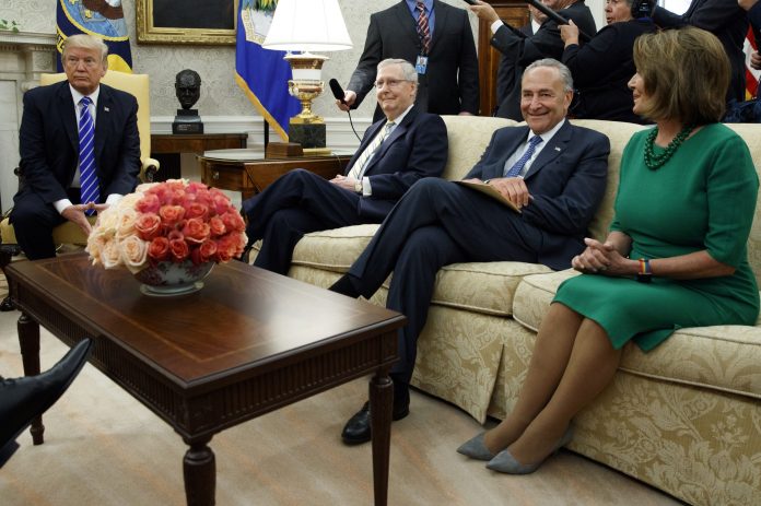 FILE - In this Sept. 6, 2017, photo, President Donald Trump pauses during a meeting with, from left, Senate Majority Leader Mitch McConnell, R-Ky., Senate Minority Leader Chuck Schumer, D-N.Y., House Minority Leader Nancy Pelosi, D-Calif., and other Congressional leaders in the Oval Office of the White House, Wednesday, Sept. 6, 2017, in Washington. The president genially calls them "Chuck and Nancy." Schumer and Pelosi, have used two White House meetings to become Trump's dealmaking partners on budget and immigration. They have a combined 67-year record of being willing negotiators in Congress. But they're also partisan Democrats perfectly happy to rumble. (AP Photo/Evan Vucci)