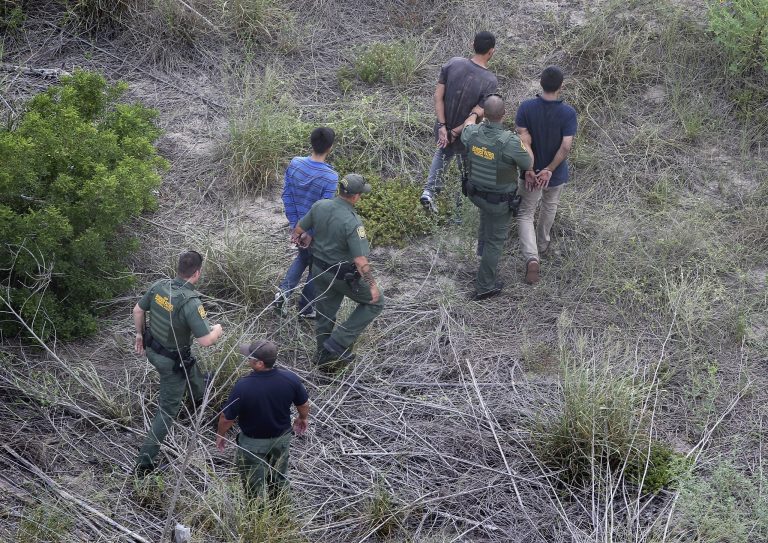 U.S. Border Patrol agents detain undocumented immigrants after a foot chase on July 25, 2014 near Falfurrias, Texas. (Photo by John Moore/Getty Images)