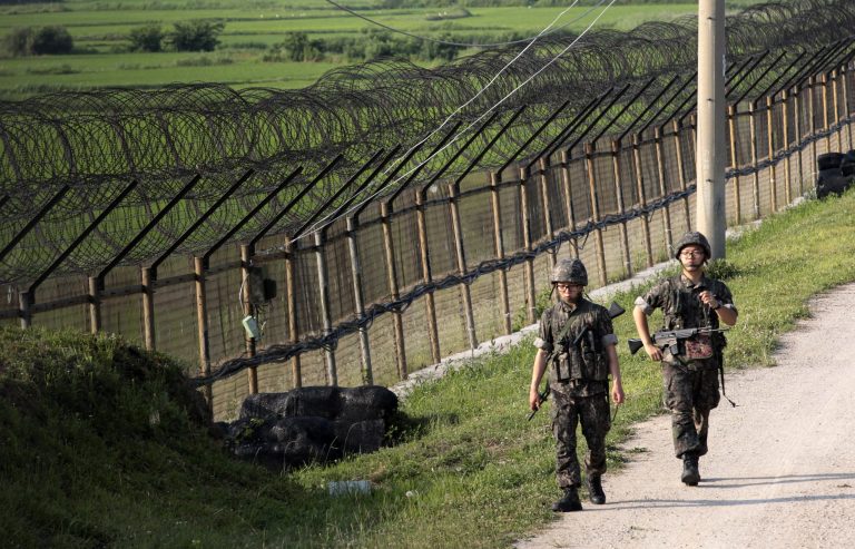 FILE - In this June 30, 2014 file photo, South Korean army soldiers patrol through the military wire fence in Paju, near the border with North Korea, South Korea.  Border guards of the rival Koreas exchanged gunfire Sunday, Oct. 19, 2014,  along their heavily fortified border in the second such shootout in less than 10 days, South Korean officials said.  (AP Photo/Ahn Young-joon, File)
