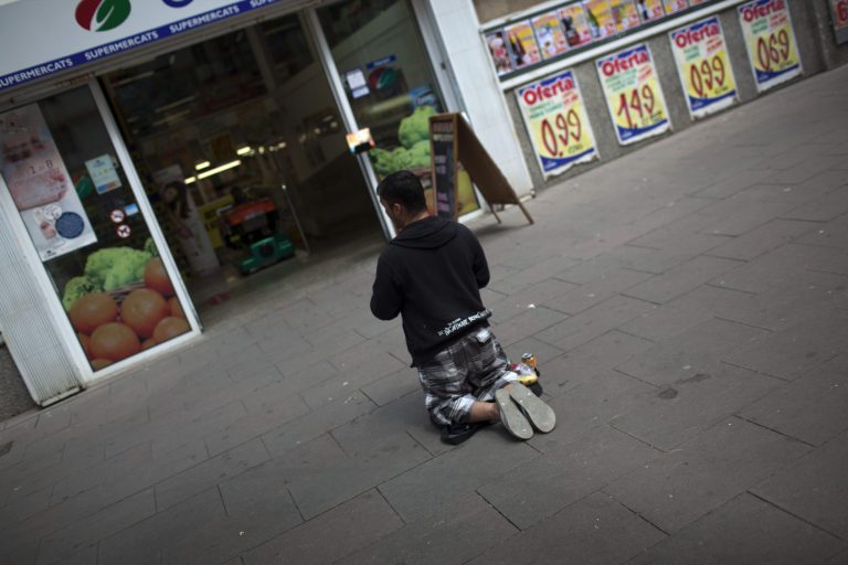   A man begs in front of a fruit market in Barcelona, Spain, Friday June 8, 2012. Spain faces rising pressure to find a financial lifeline for its deeply troubled banks â likely from the eurozone's rescue fund since Madrid's borrowing costs on markets have risen sharply. (AP Photo/Emilio Morenatti)  