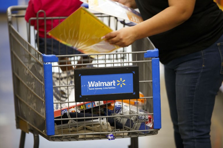 A customer places school supplies into a shopping cart at a Walmart in Burbank, Calif. in August 2017. The company expects a $2 billion windfall this year from GOP-led tax cuts. Photographer: Patrick T. Fallon/Bloomberg