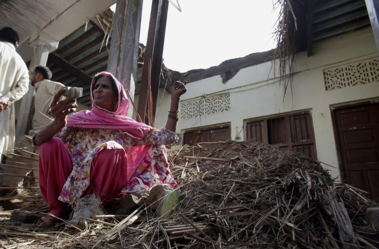 Rehmat Bibi shows a motor shell while she sits on the rubble of her house, damaged during clashes between Pakistani forces and Indian's, in Dhamala Hakimwala village in Pakistan's Punjab province, Wednesday, Oct. 8, 2014. Troops traded heavy fire between Pakistan and Indian-controlled Kashmir, killing several civilians and worsening tensions between the long-time rivals, officials on both sides said Wednesday. The violence has spread since Sunday night along the 200-kilometer (125-mile) border between Pakistan's Punjab province and the Indian-controlled portion of Kashmir. (AP Photo/Anjum Naveed)