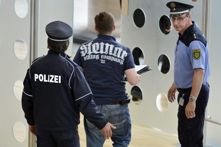   Poice accompany lawmakers of the right-wing NPD out of the federal parliament of Saxony state in Dresden, Wednesday June 13, 2012. The president of Saxony's state parliament has expelled eight far-right lawmakers from the assembly for wearing clothes favored by German neo-Nazis. Saxony state parliament spokesman Ivo Klatte said the NPD party lawmakers on Wednesday declined to remove T-shirts and shirts featuring the Thor Steinar logo in an 