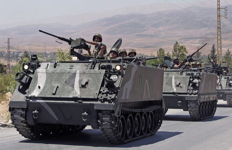 Lebanese army reinforcements arrive to the outskirts of Arsal, a predominantly Sunni Muslim town near the Syrian border in eastern Lebanon, Monday, Aug. 4, 2014. Thousands of Lebanese civilians and Syrian refugees packed cars and pickup trucks Monday, fleeing an eastern border town that was overrun by militants from neighboring Syria as Lebanese troops fight to liberate the area. (AP Photo/Bilal Hussein)