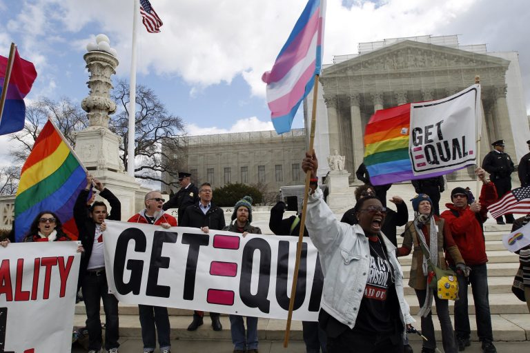 Demonstrators hold flags and chant in front of the Supreme Court in Washington on the second day of gay marriage cases before the court in March. (AP/Jose Luis Magana)