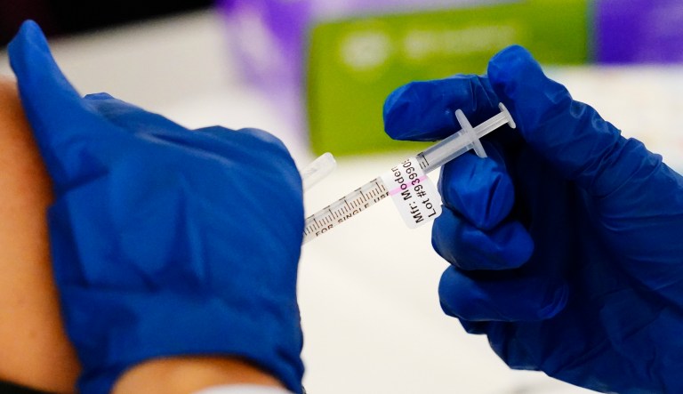 FILE - A health worker administers a dose of a Moderna COVID-19 vaccine during a vaccination clinic at the Norristown Public Health Center in Norristown, Pa., Tuesday, Dec. 7, 2021. The FDA's panel of vaccine experts voted Tuesday to recommend the shots in children ages 6 to 17. (AP Photo/Matt Rourke, File)