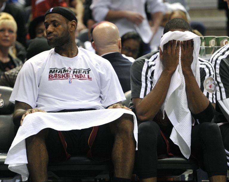   Miami Heat's LeBron James, left , and Dwyane Wade sit on the bench in the closing seconds of an NBA basketball game against the Milwaukee Bucks, Saturday, Dec. 29, 2012, in Milwaukee. The Bucks defeated the Heat 104-85. (AP Photo/Jim Prisching)  