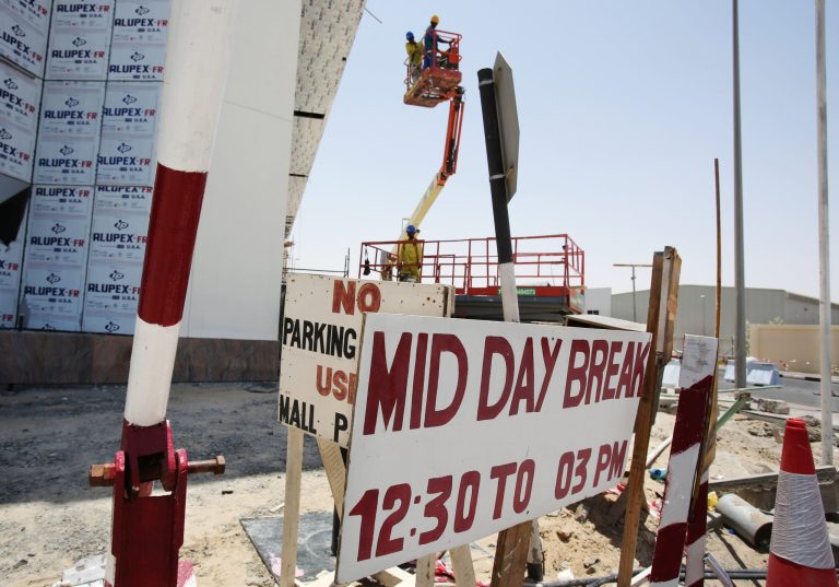 In this Sunday, June 15, 2014 photo, laborers descend in a lift as they start their midday break at the Dragon Mart Phase 2 construction site in Dubai, United Arab Emirates. A midday work ban goes into effect across the United Arab Emirates for construction workers and outdoor laborers, on Sunday, to protect them from the risks of direct sunlight and extremely high temperatures during the hottest summer months. (AP Photo/Kamran Jebreili)