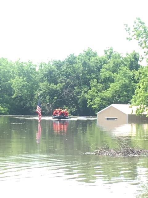 Recusers move towards an American flag as flooding continues in Oklahoma.
