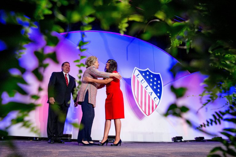 Democratic presidential candidate Hillary Clinton, accompanied by LULAC President Roger C. Rocha, Jr., left, hugs University of Texas student Dreamer Lizeth Urdiales, right, as she arrives to speaks at the 87th League of United Latin American Citizens National Convention at the Washington Hilton in Washington, Thursday, July 14, 2016. (AP Photo/Andrew Harnik)