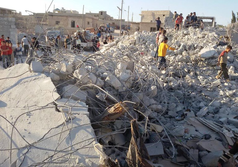 FILE - In this Sept. 23, 2014 file photo, provided by an anti-Bashar Assad activist group Edlib News Network (ENN), which has been authenticated based on its contents and other AP reporting, shows Syrian citizens checking a damaged house that they say was targeted by the coalition airstrikes, in the village of Kfar Derian, a base for the al-Qaida-linked Nusra Front, a rival of the Islamic State group, between the northern province of Aleppo and Idlib, Syria. The barrage of U.S. cruise missiles last month aimed at a terror cell in Syria killed just one or two of the key militants, according to American intelligence officials who say the al-Qaida group is still believed to be plotting attacks against targets in the United States and Europe.  (AP Photo/Edlib News Network ENN, File)