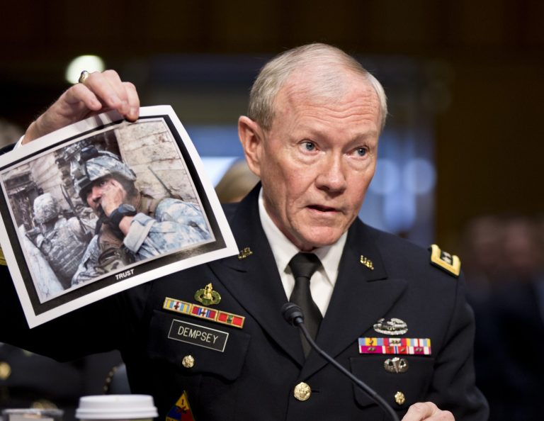   FILE - In this July 18, 2013, file photo, Gen. Martin Dempsey, chairman of the Joint Chiefs of Staff, holds up a photo of a deployed American soldier as he testifies before the Senate Armed Services Committee at his reappointment hearing, on Capitol Hill in Washington. The Obama administration is opposed to even limited U.S. military intervention in Syria because it believes rebels fighting the Assad regime wouldnât support American interests if they were to seize power right now, Dempsey said in a letter to a congressman obtained by The Associated Press. (AP Photo/J. Scott Applewhite, File)  