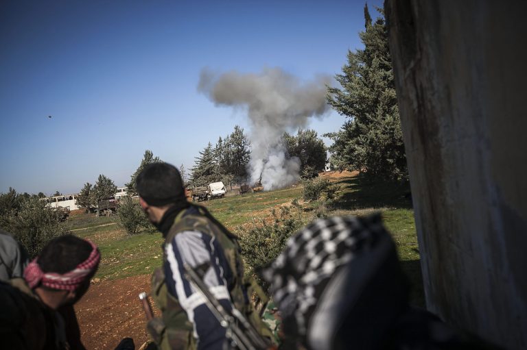   In this Saturday, Dec. 15, 2012 photo, Free Syrian Army fighters react after an explosion during heavy clashes with government forces at a military academy besieged by the rebels north of Aleppo, Syria. Free Syrian Army fighters took control over the military academy after battling government forces for several hours. (AP Photo/Narciso Contreras)  