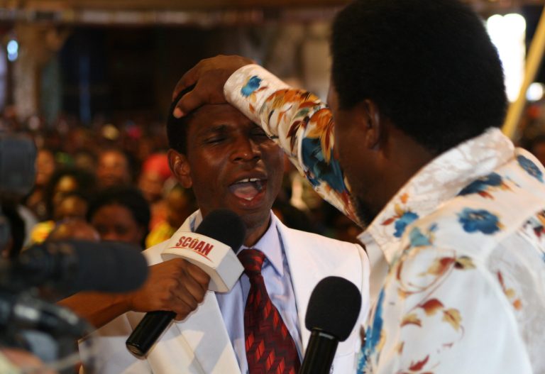 FILE - In this Sunday, Sept. 15, 2013 file photo, T.B. Joshua lays his hand on the head of a worshipper during a service at the Synagogue, Church of All Nations, in Lagos Nigeria. T.B. Joshua's Synagogue, Church of All Nations has branches around the world, and a recent YouTube video even credits him with predicting the disappearance of Malaysian Airlines Flight MH370. Joshua is one of the best-known preachers in Africa and among the most profitable in Nigeria, the go-to faith healer and spiritual guide for leaders such as the late Ghanaian president John Atta Mills, Malawian president Joyce Banda and former Zimbabwean prime minister Morgan Tsvangirai. The man who says he comes from the poor village of Arigidi is worth between $10 and $15 million based on assets, according to Forbes magazine, which in 2011 estimated his personal wealth. The church holds some 15,000 people with outside tents for the overflow and Sunday services are beamed worldwide.  Yet critics say this wildly popular televangelist hinders efforts to curtail the spread of HIV and tuberculosis with testimonies by church-goers that faith and his holy water can cure both.  He is also accused of taking advantage of his followers and tightly controlling those closest to him, who call him 
