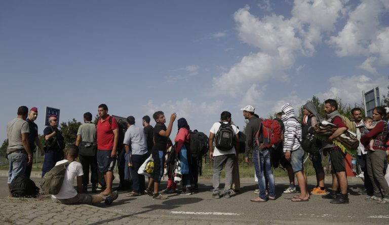 Migrants line up while crossing the border from Croatia into Beremend, Hungary, on Saturday, Sept. 19, 2015. 