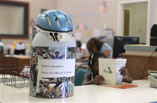 In this photo taken Wednesday, Aug. 29, 20132, a  bicycle helmet tops the container where students with a month's worth of perfect attendance can enter their names in a raffle to win the helmet and bicycle at the Maeola R. Beitzel Elementary School in Sacramento, Calif.    Beitzel elementary is among the schools in the Elk Grove Unified School participating in the districts 