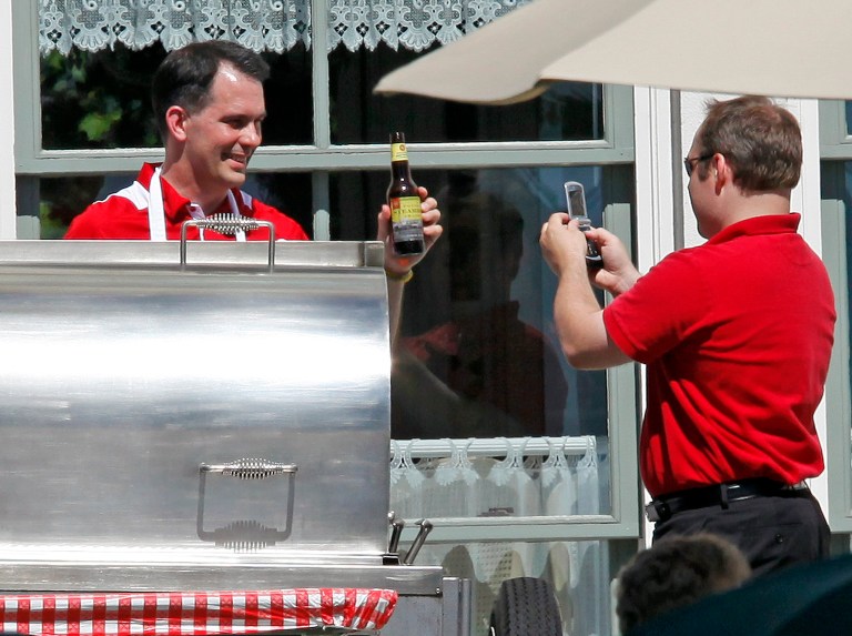   Wisconsin Gov. Scott Walker poses for a picture with a bottle of beer while manning the grill as he hosts a Brat Summit at the Executive Residence in the Village of Maple Bluff, Wis., Tuesday, June 12, 2012. Walker, just a week removed from his win in a recall election spurred by his taking on public sector unions, did not allow media into the cookout. He billed the bipartisan gathering as a way to heal political wounds following his first 18 months in office that has spurred massive protests and culminated with the unsuccessful recall attempt. (AP Photo/Wisconsin State Journal, M.P. King)  