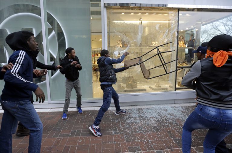 A protestor breaks a window at a store after a rally for Freddie Gray, April 25, 2015, in Baltimore. (AP Photo/Patrick Semansky)