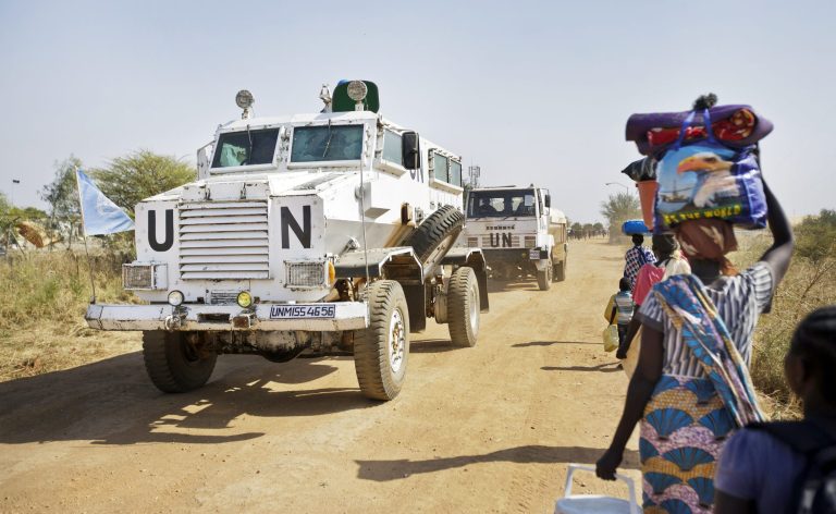 A United Nations armored vehicle passes displaced people walking towards the U.N. camp in Malakal, South Sudan. President Trump's proposed deep cuts in foreign aid could mark the retreat of U.S. support for South Sudan. (AP Photo/Ben Curtis)