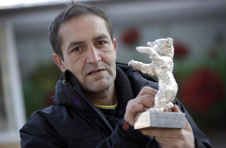 In this photo taken Saturday, Jan. 25, 2014, Bosnian actor Nazif Mujic holds his Silver Bear Best Actor award for his role in 'An Episode In the Life of an Iron Picker' prior to an interview with the Associated Press in Berlin, Germany. Mujic, a Roma from a tiny village in Bosnia, won the Silver Bear award in 2013. Now, almost a year later, the movie star has turned into an asylum seeker.  Mujic is back in Berlin, but this time he came with his family to apply for asylum, was rejected by the German authorities and is desperately fighting his deportation back to Bosnia in March. (AP Photo/Michael Sohn)