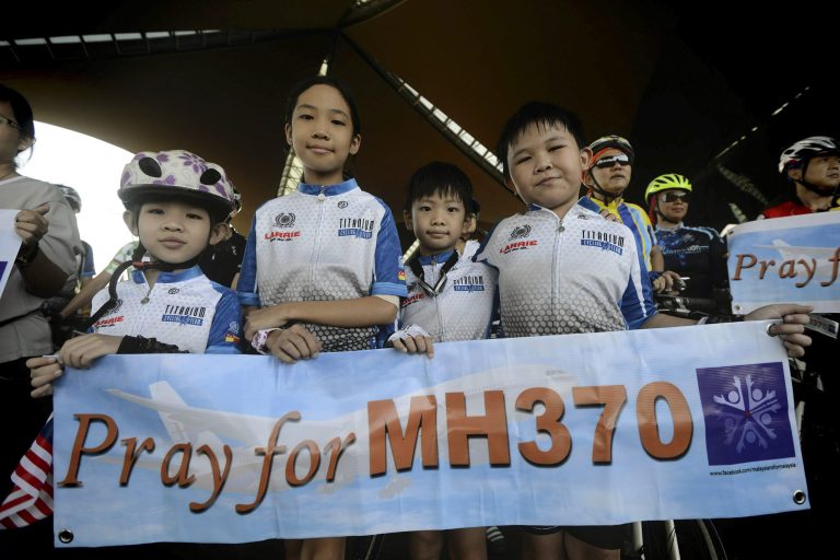 Cyclists hold a banner reading 