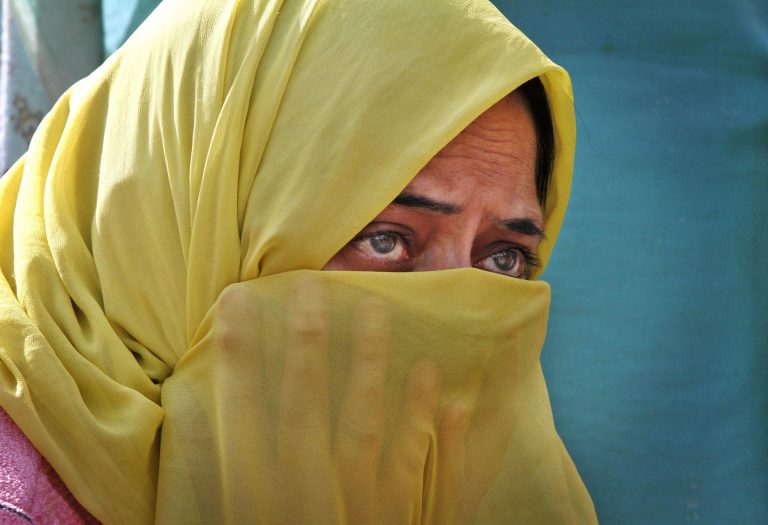 A Kashmiri woman blocks a road during a protest demanding rehabilitation of affected people in flooded areas, in Srinagar, India, Wednesday, Oct. 15, 2014. Flooding in the conflict-wracked Himalayan region in early September killed 281 people, destroyed at least 100,000 homes and caused an estimated $17 billion in damage. (AP Photo/Mukhtar Khan)