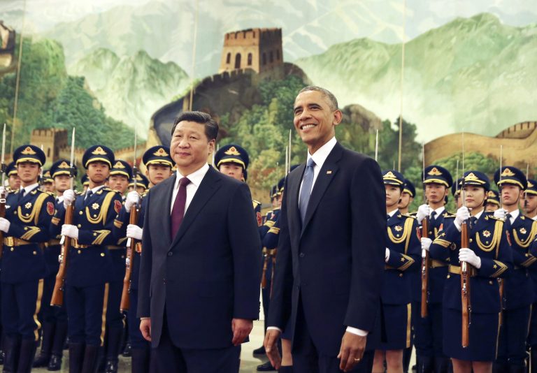 President Obama, right, smiles after a group of children waved flags and flowers to cheer him during a welcome ceremony with Chinese President Xi Jinping at the Great Hall of the People in Beijing, China Wednesday. (AP Photo/Andy Wong)