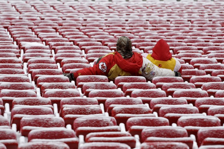 FILE - Fans sit in snowy seats at Arrowhead Stadium as they wait for the start of an NFL football game between the Kansas City Chiefs and the Indianapolis Colts in this Dec. 22, 2013 file photo, in Kansas City, Mo. Many NFL teams are following the leads of other sports _ dropping prices for less desirable games while jacking up costs for the biggest matchups. (AP Photo/Charlie Riedel, File)