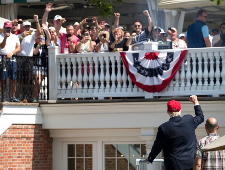 President Donald Trump turns to the clubhouse crowd as he arrives to enter his presidential viewing stand, Sunday, July 16, 2017, during the U.S. Women's Open Golf tournament at Trump National Golf Club in Bedminster, N.J. (AP Photo/Carolyn Kaster)