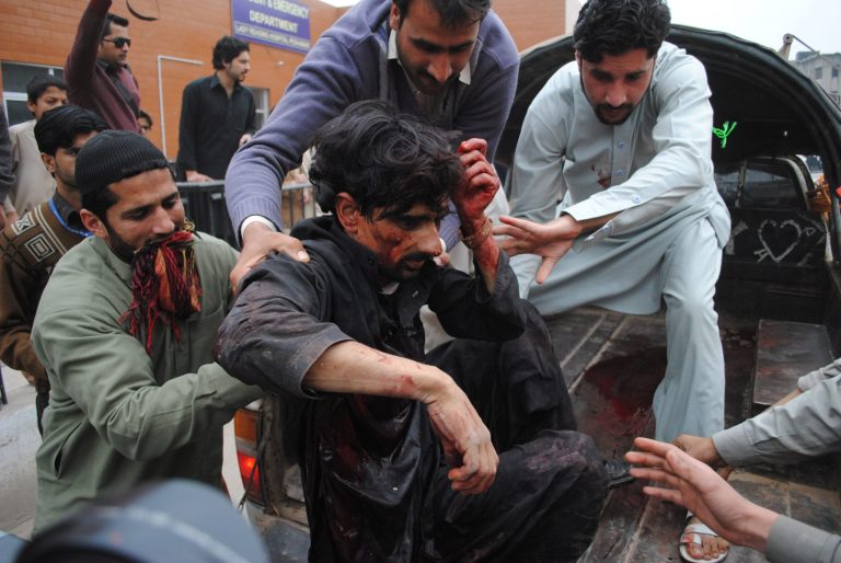 People carry an injured person to a local hospital in Peshawar, Pakistan, Friday, March 14, 2014. Pakistani officials said a suicide attacker has blown himself up near a police armored vehicle outside the northwestern city of Peshawar, killing several  people. (AP Photo/Mohammad Sajjad)