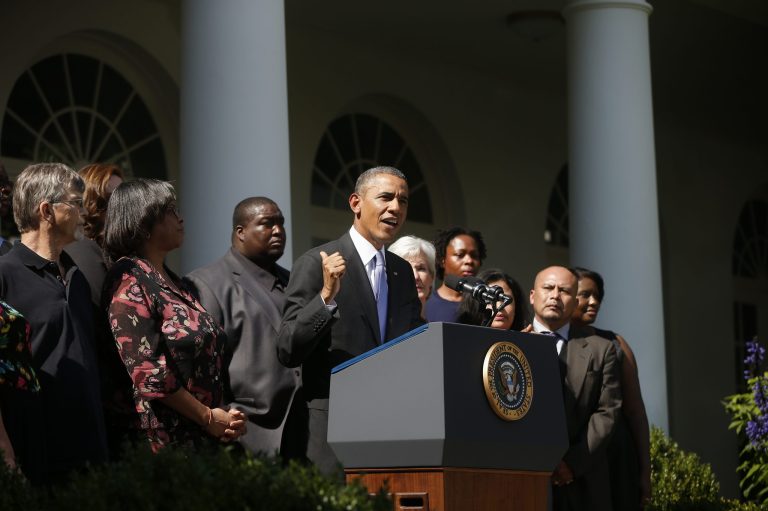  President Barack Obama, stands with Health and Human Services Secretary Kathleen Sebelius and people who support the Affordable Care Act, his signature health care law, as he speaks in the Rose Garden of the White House in Washington, Tuesday, Oct. 1, 2013. Congress plunged the nation into a partial government shutdown Tuesday as a long-running dispute over President Barack Obama's health care law forced about 800,000 federal workers off the job, suspending all but essential services. (AP Photo/Charles Dharapak)  