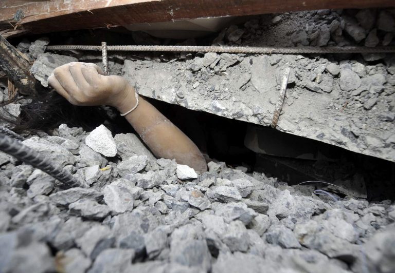A trapped worker calls for help from the rubble of a collapsed building in Pathumthani province, central Thailand, Monday, Aug. 11, 2014. A six-story building under construction on the outskirts of Thailand's capital collapsed Monday, killing a number of workers and trapping several others underneath the rubble, police said. (AP Photo) THAILAND OUT