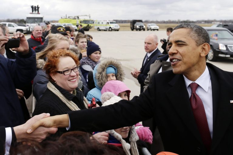   President Barack Obama greets well-wishers after stepping off Air Force One upon his arrival at Metropolitan Wayne County Airport in Detroit, Monday, Dec. 10, 2012, before going to the Daimler Detroit Diesel plant in Redford, Mich. (AP Photo/Charles Dharapak)  