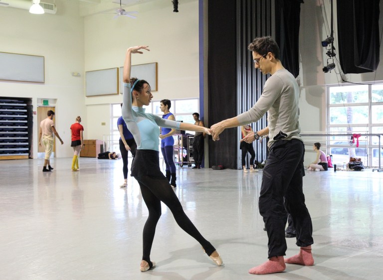 In this July 31, 2014 photo provided by the Miami City Ballet, choreographer Justin Peck, right, works with a dancer in the studio in Miami Beach, Fla. Miami City Ballet will debut in March a new work that is a collaboration between Peck and street artist Shepard Fairey. Peck is a soloist and choreographer at New York Ballet. (AP Photo/Miami City Ballet, Daniel Azoulay)