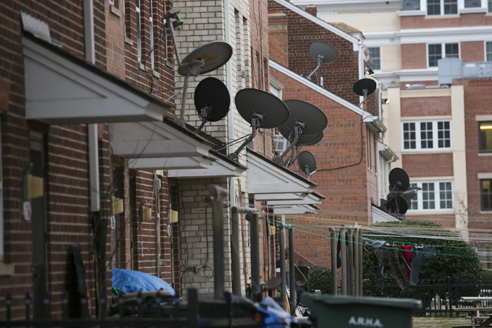 Satellite television dishes attached to a row of housing projects in Old Town Alexandria, VA. (Graeme Jennings/Washington Examiner)