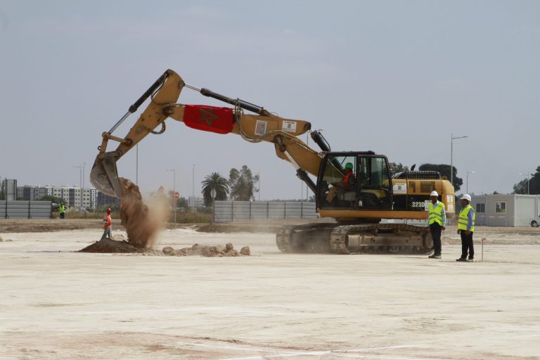 A backhoe breaks ground on a new electronics factory near Casablanca Airport, Morocco in a ceremony attended by Industry Minister Hafid Alamy. The multinational energy company Eaton broke ground on a new $12 million electronics plant Monday in the latest example of foreign investment in Morocco. (AP Photo/Paul Schemm)